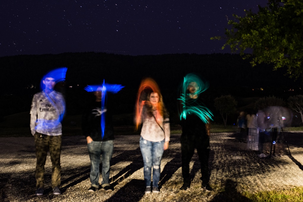 Students spelling out "STAR" with light sticks.