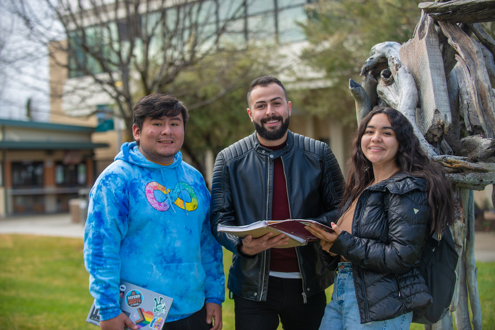 Students standing by sculpture